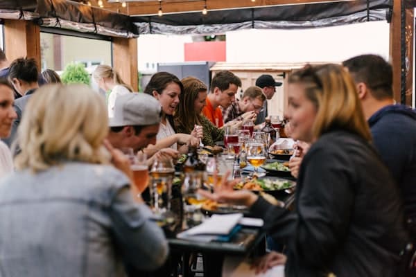 Club members sharing a meal together at an outdoor community dinner